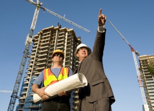 Contractor and foreman at the job site construction in the background